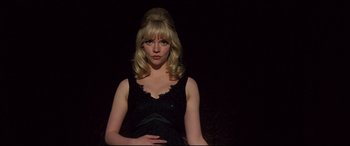 Movie still from “Last Night in Soho” (2021), directed by Edgar Wright – A woman in a black dress posing for a picture; Medium shot, Low angle