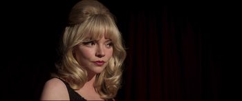 Movie still from “Last Night in Soho” (2021), directed by Edgar Wright – A woman with blonde hair wearing a black dress; Close Up shot, Over the shoulder angle