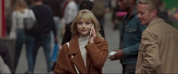 Movie still from “Last Night in Soho” (2021), directed by Edgar Wright – A young woman talking on a cell phone while walking down the street; Close Up shot, Over the shoulder angle