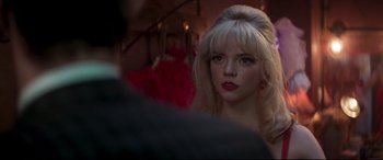 Movie still from “Last Night in Soho” (2021), directed by Edgar Wright – A woman with blonde hair and red lipstick looking into the camera; Close Up shot, Over the shoulder angle