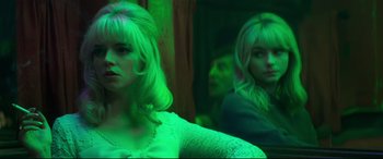 Movie still from “Last Night in Soho” (2021), directed by Edgar Wright – A woman standing in front of a mirror in front of another woman; Medium shot, Over the shoulder angle