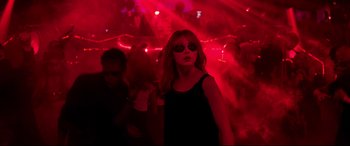 Movie still from “Last Night in Soho” (2021), directed by Edgar Wright – A woman in a black dress and sunglasses in a red room; Medium shot, Over the shoulder angle