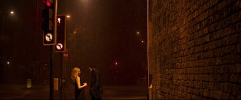 Movie still from “Last Night in Soho” (2021), directed by Edgar Wright – A man and a woman standing next to each other on a street; Extreme Wide shot, Low angle