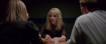 Movie still from “Last Night in Soho” (2021), directed by Edgar Wright – A woman sitting at a table in a dark room; Close Up shot, Over the shoulder angle