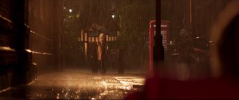Movie still from “Last Night in Soho” (2021), directed by Edgar Wright – A person holding an umbrella while standing in the rain; Extreme Wide shot, Low angle
