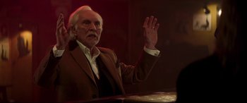 Movie still from “Last Night in Soho” (2021), directed by Edgar Wright – An older man in a brown suit is waving; Close Up shot, Low angle