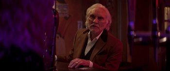 Movie still from “Last Night in Soho” (2021), directed by Edgar Wright – An older man sitting at a bar looking at the camera; Close Up shot, Low angle