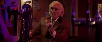 Movie still from “Last Night in Soho” (2021), directed by Edgar Wright – An old man sitting at a table in a bar; Medium shot, Over the shoulder angle