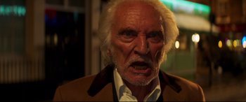 Movie still from “Last Night in Soho” (2021), directed by Edgar Wright – An old man with a white beard is looking at the camera; Close Up shot, Low angle