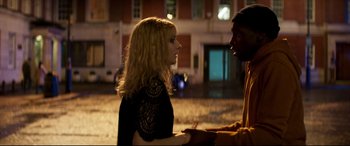 Movie still from “Last Night in Soho” (2021), directed by Edgar Wright – A woman in a black dress talking to a man in a yellow jacket; Medium shot, Over the shoulder angle