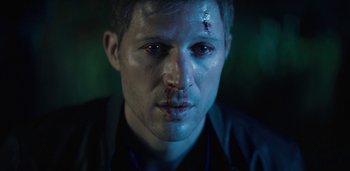 Movie still from “Midnight Mass” (2021), directed by Mike Flanagan – A person with blood on his face; Close Up shot, High angle