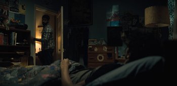 Movie still from “Midnight Mass” (2021), directed by Mike Flanagan – Two people in a room looking at each other; Wide shot, Over the shoulder angle