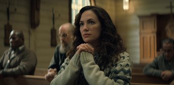 Movie still from “Midnight Mass” (2021), directed by Mike Flanagan – A woman with her hands clasped in front of a man; Close Up shot, Low angle