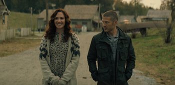 Movie still from “Midnight Mass” (2021), directed by Mike Flanagan – A man and a woman standing next to each other on the street; Medium shot, Over the shoulder angle