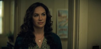 Movie still from “Midnight Mass” (2021), directed by Mike Flanagan – A beautiful woman with long dark hair wearing a necklace; Close Up shot, Over the shoulder angle