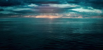 Movie still from “Midnight Mass” (2021), directed by Mike Flanagan – The sun is setting over a body of water; Extreme Wide shot, High angle