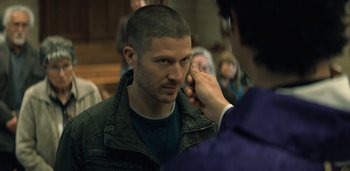 Movie still from “Midnight Mass” (2021), directed by Mike Flanagan – A man getting his hair cut by a person; Close Up shot, Over the shoulder angle