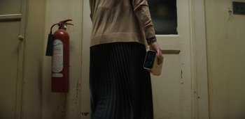 Movie still from “Midnight Mass” (2021), directed by Mike Flanagan – A woman holding a cell phone in her hand; Medium shot, Low angle