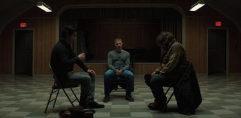 Movie still from “Midnight Mass” (2021), directed by Mike Flanagan – Three men sitting in chairs in front of each other; Wide shot, High angle