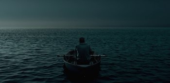 Movie still from “Midnight Mass” (2021), directed by Mike Flanagan – A man is sitting in a boat in the middle of the ocean; Extreme Wide shot, High angle