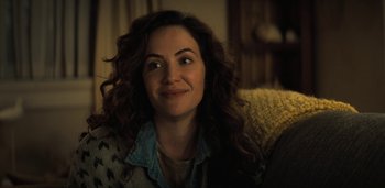 Movie still from “Midnight Mass” (2021), directed by Mike Flanagan – A person sitting on a couch; Close Up shot, Over the shoulder angle