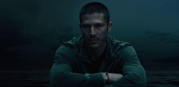 Movie still from “Midnight Mass” (2021), directed by Mike Flanagan – A person with his arms crossed; Close Up shot, Low angle