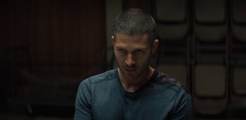 Movie still from “Midnight Mass” (2021), directed by Mike Flanagan – A person wearing a blue shirt; Close Up shot, Over the shoulder angle