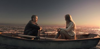 Movie still from “Midnight Mass” (2021), directed by Mike Flanagan – A man and a woman sitting in a boat on the water; Wide shot, Over the shoulder angle