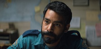 Movie still from “Midnight Mass” (2021), directed by Mike Flanagan – A person with a beard; Close Up shot, Over the shoulder angle