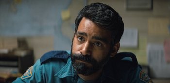 Movie still from “Midnight Mass” (2021), directed by Mike Flanagan – A person with a beard; Close Up shot, Over the shoulder angle