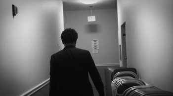 Movie still from “Mike Epps: Only One Mike” (2019), directed by Kevin Bray – A man in a suit walking down a hall way; Medium shot, Low angle