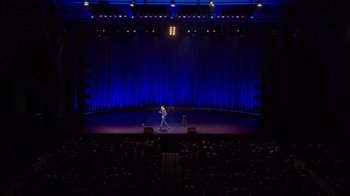 Movie still from “Mike Epps: Only One Mike” (2019), directed by Kevin Bray – A man standing on a stage in front of an audience; Extreme Wide shot, High angle