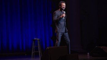 Movie still from “Mike Epps: Only One Mike” (2019), directed by Kevin Bray – A man standing on a stage holding a microphone; Wide shot, High angle