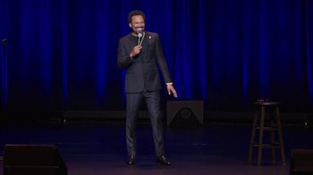 Movie still from “Mike Epps: Only One Mike” (2019), directed by Kevin Bray – A man standing on a stage holding a microphone; Medium shot, High angle