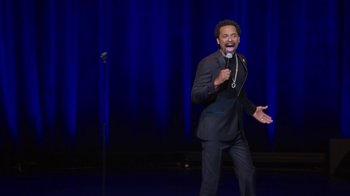 Movie still from “Mike Epps: Only One Mike” (2019), directed by Kevin Bray – A man standing on a stage holding a microphone; Medium shot, High angle