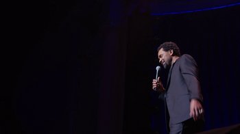 Movie still from “Mike Epps: Only One Mike” (2019), directed by Kevin Bray – A man standing on a stage holding a microphone; Medium shot, Low angle