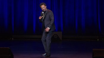 Movie still from “Mike Epps: Only One Mike” (2019), directed by Kevin Bray – A man standing on a stage holding a microphone; Medium shot, High angle