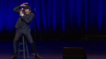 Movie still from “Mike Epps: Only One Mike” (2019), directed by Kevin Bray – A man standing on a stage with a microphone; Medium shot, High angle
