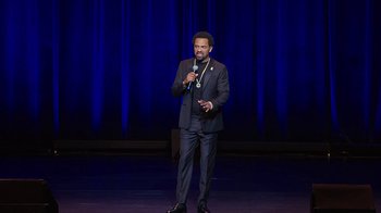 Movie still from “Mike Epps: Only One Mike” (2019), directed by Kevin Bray – A man standing on a stage holding a microphone; Wide shot, High angle