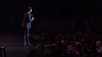 Movie still from “Mike Epps: Only One Mike” (2019), directed by Kevin Bray – A man standing on a stage in front of an audience; Extreme Wide shot, High angle