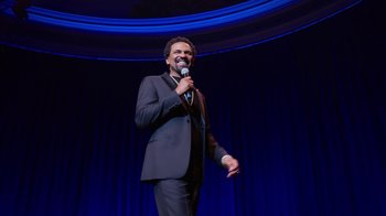 Movie still from “Mike Epps: Only One Mike” (2019), directed by Kevin Bray – A man standing on a stage holding a microphone; Medium shot, Low angle