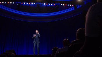 Movie still from “Mike Epps: Only One Mike” (2019), directed by Kevin Bray – A man standing on a stage with a microphone; Extreme Wide shot, Low angle