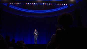 Movie still from “Mike Epps: Only One Mike” (2019), directed by Kevin Bray – A man standing on a stage in front of an audience; Extreme Wide shot, Low angle