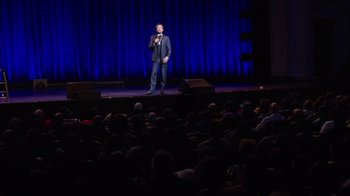 Movie still from “Mike Epps: Only One Mike” (2019), directed by Kevin Bray – A man standing on a stage in front of an audience; Extreme Wide shot, High angle