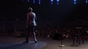Movie still from “Mike Epps: Only One Mike” (2019), directed by Kevin Bray – A man standing on a stage in front of an audience; Wide shot, Over the shoulder angle