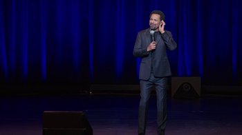 Movie still from “Mike Epps: Only One Mike” (2019), directed by Kevin Bray – A man standing on a stage holding a microphone; Medium shot, High angle