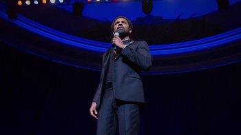 Movie still from “Mike Epps: Only One Mike” (2019), directed by Kevin Bray – A man standing on a stage holding a microphone; Medium shot, Low angle