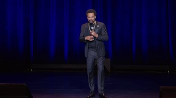 Movie still from “Mike Epps: Only One Mike” (2019), directed by Kevin Bray – A man standing on a stage holding a microphone; Medium shot, High angle