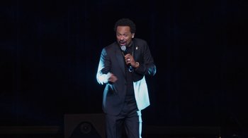Movie still from “Mike Epps: Only One Mike” (2019), directed by Kevin Bray – A man standing on a stage holding a microphone; Medium shot, High angle