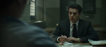 Movie still from “Mindhunter” (2017), directed by Tobias Lindholm – A man sitting at a table writing on a piece of paper; Close Up shot, Over the shoulder angle